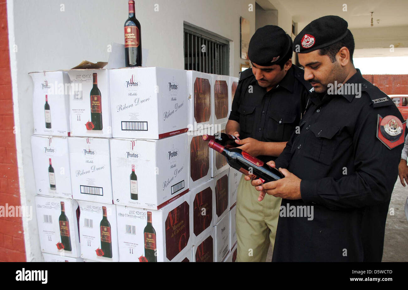 I funzionari di polizia ispezionare sequestrati illegale di liquori  importati bottiglie che sono state recuperate in un raid al magazzino di  Stato industriale durante la conferenza stampa a Hayatabad stazione di  polizia