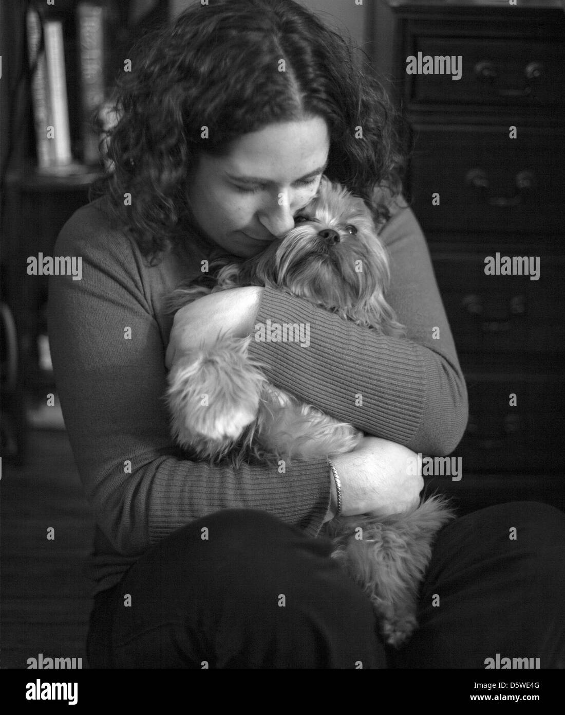 Una donna che tiene il suo cane e coccole con esso. Foto Stock