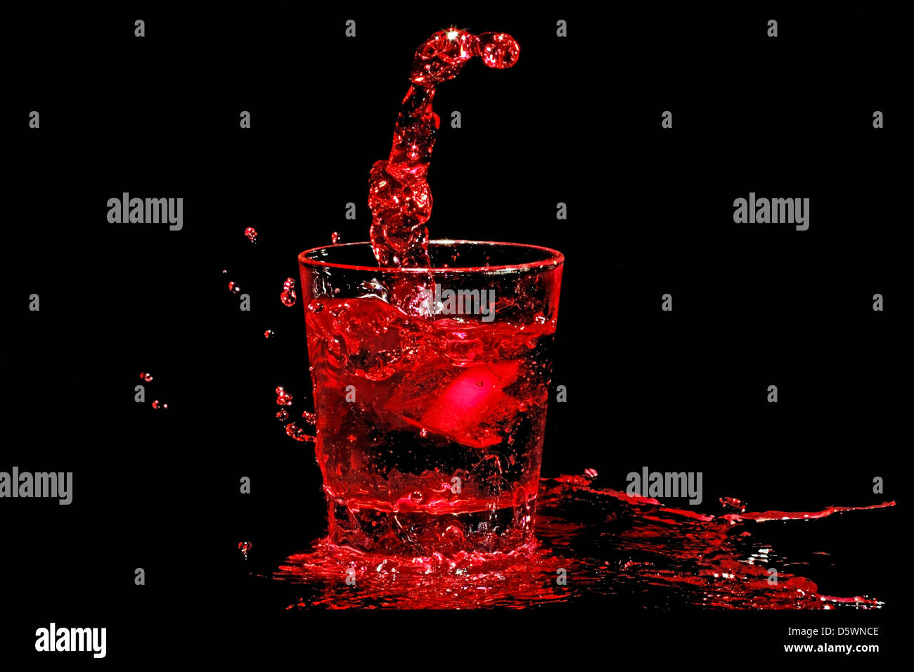 Il cubo di ghiaccio schizzi in un bicchiere di vino rosso Foto Stock