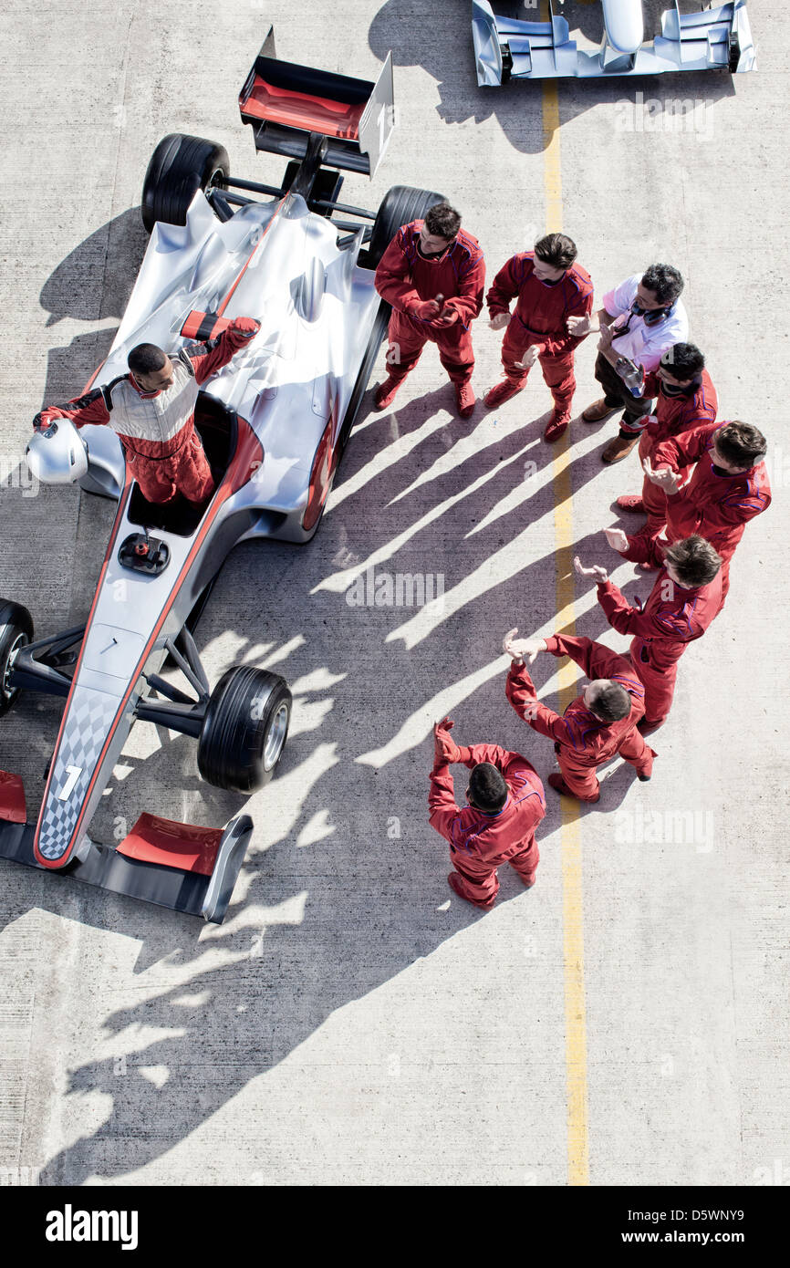 Racing team che circonda racer su via Foto Stock