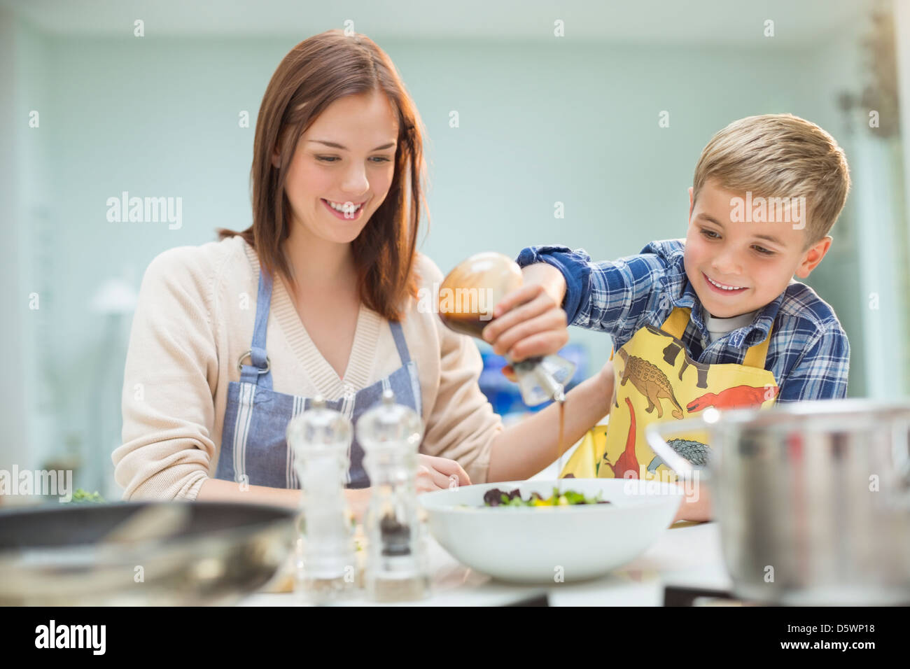 Madre e figlio facendo insalata in cucina Foto Stock