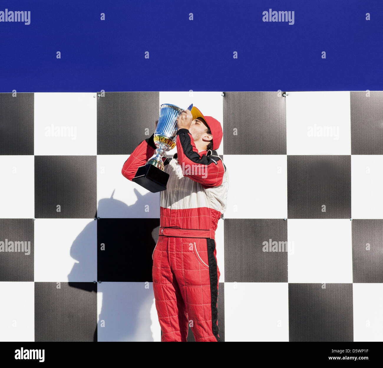 Racer kissing trofeo alla cerimonia di premiazione Foto Stock
