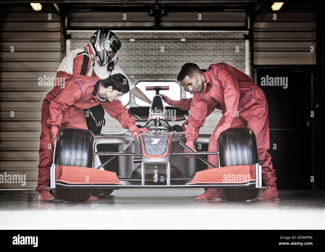 Racing team che lavorano in garage Foto Stock