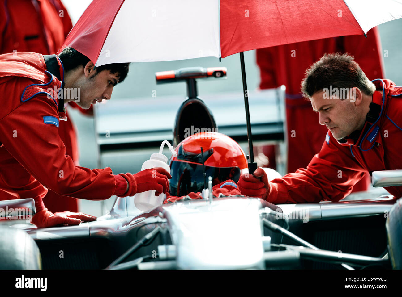 Racer e team di lavoro in pit stop Foto Stock