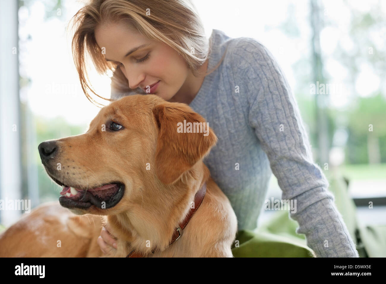 Donna rilassante con il cane in ambienti interni Foto Stock