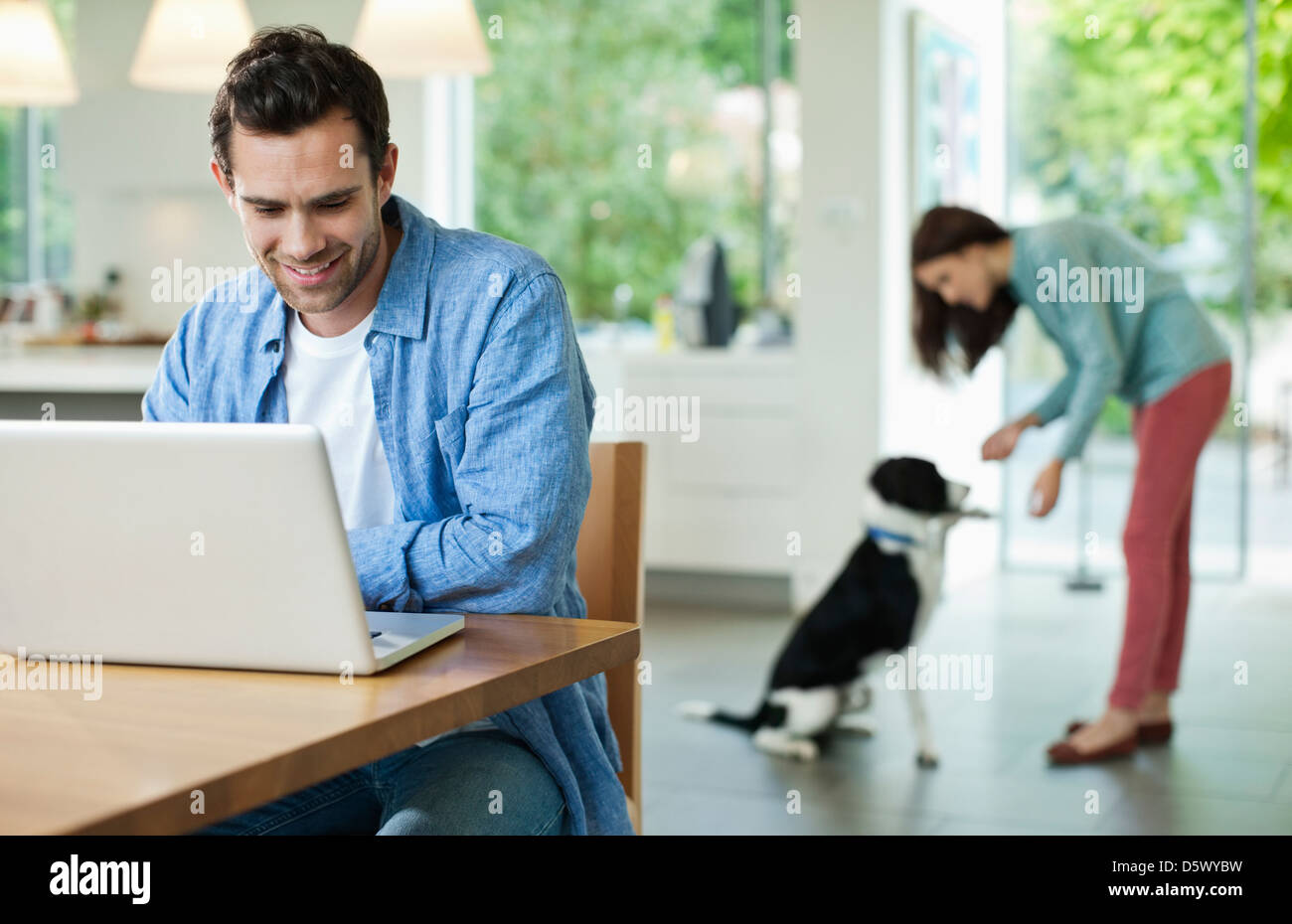 Uomo con notebook al tavolo della cucina Foto Stock