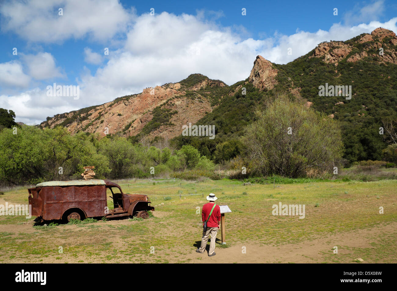 Escursionista legge segno interpretative a M*A*S*H ubicazione sito in Malibu Creek State Park Foto Stock