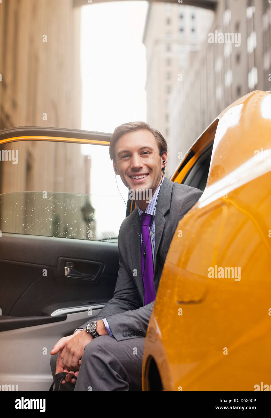 Imprenditore seduto in un taxi sulla strada di città Foto Stock