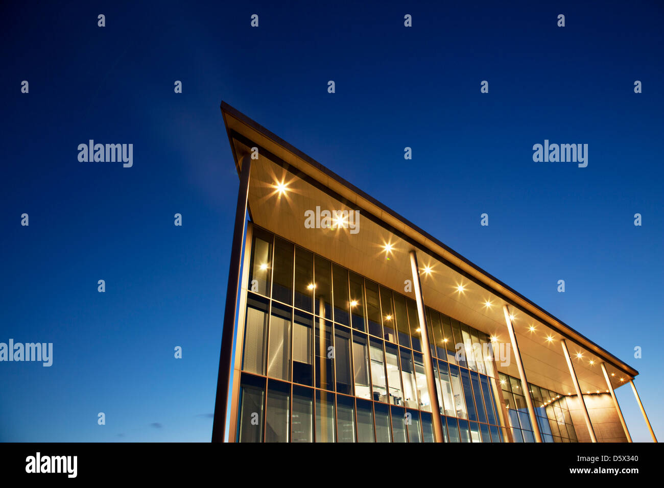 Edificio moderno illuminato al crepuscolo Foto Stock