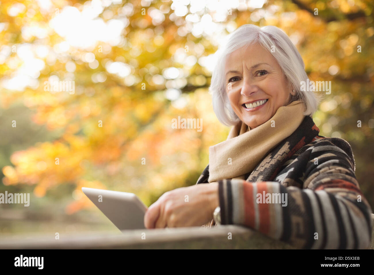 Donna anziana utilizzando computer tablet all'aperto Foto Stock