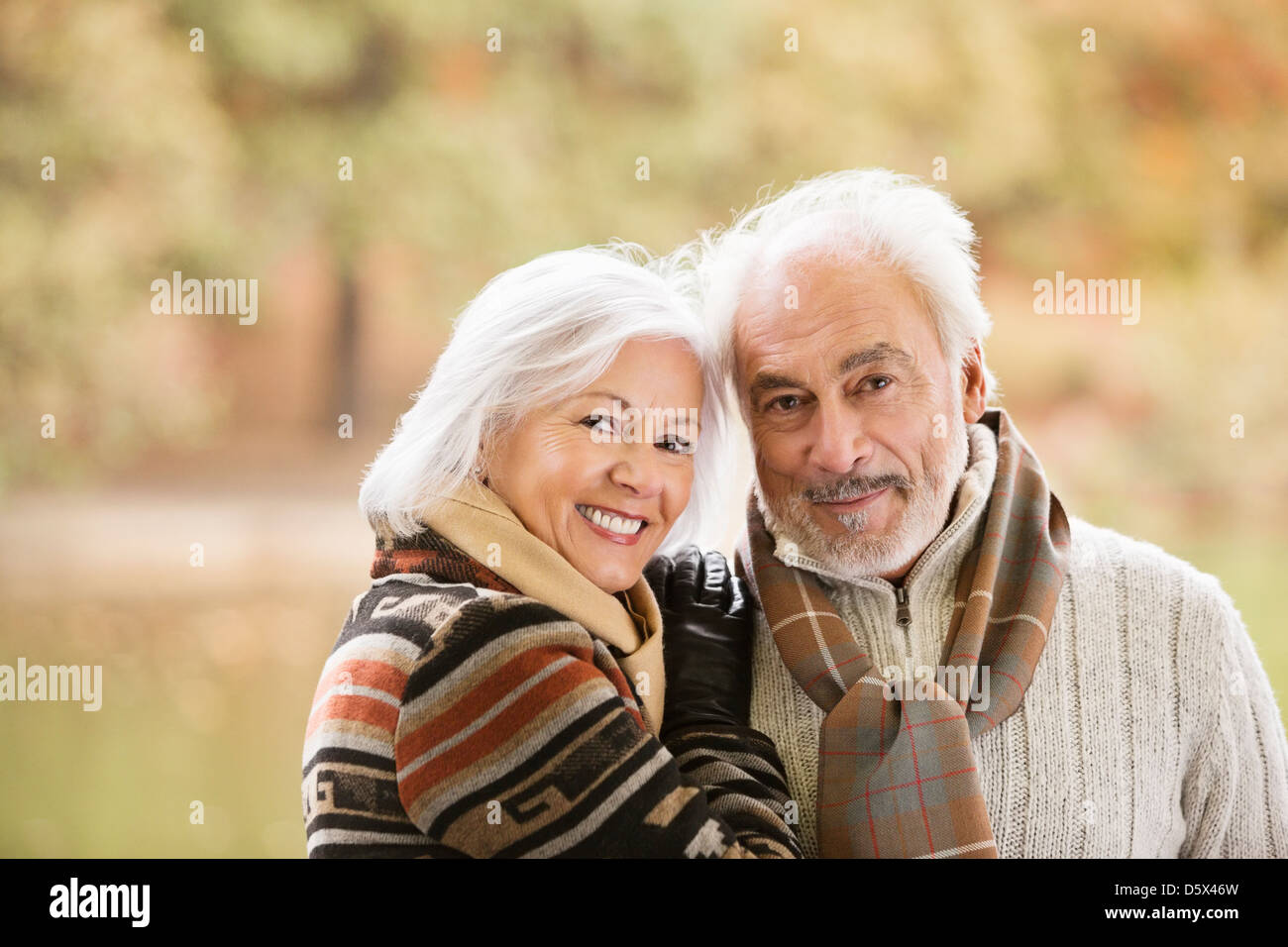 Anziana coppia sorridente insieme in posizione di parcheggio Foto Stock