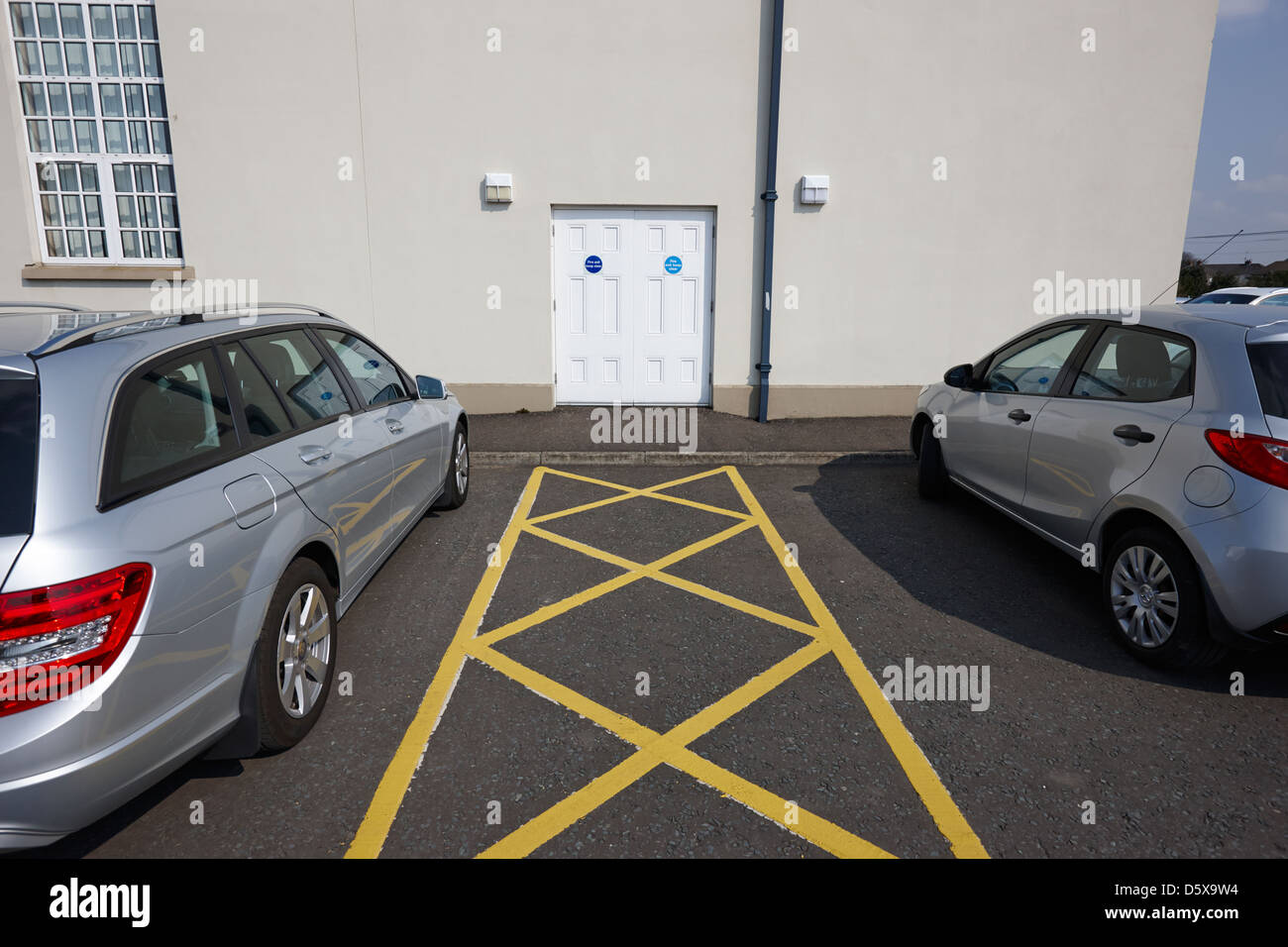 Uscita ANTINCENDIO, LASCIARE LIBERO IL PASSO le porte di emergenza e parcheggio auto iscrizioni in un accesso pubblico edificio moira county down Irlanda del Nord Regno Unito Foto Stock