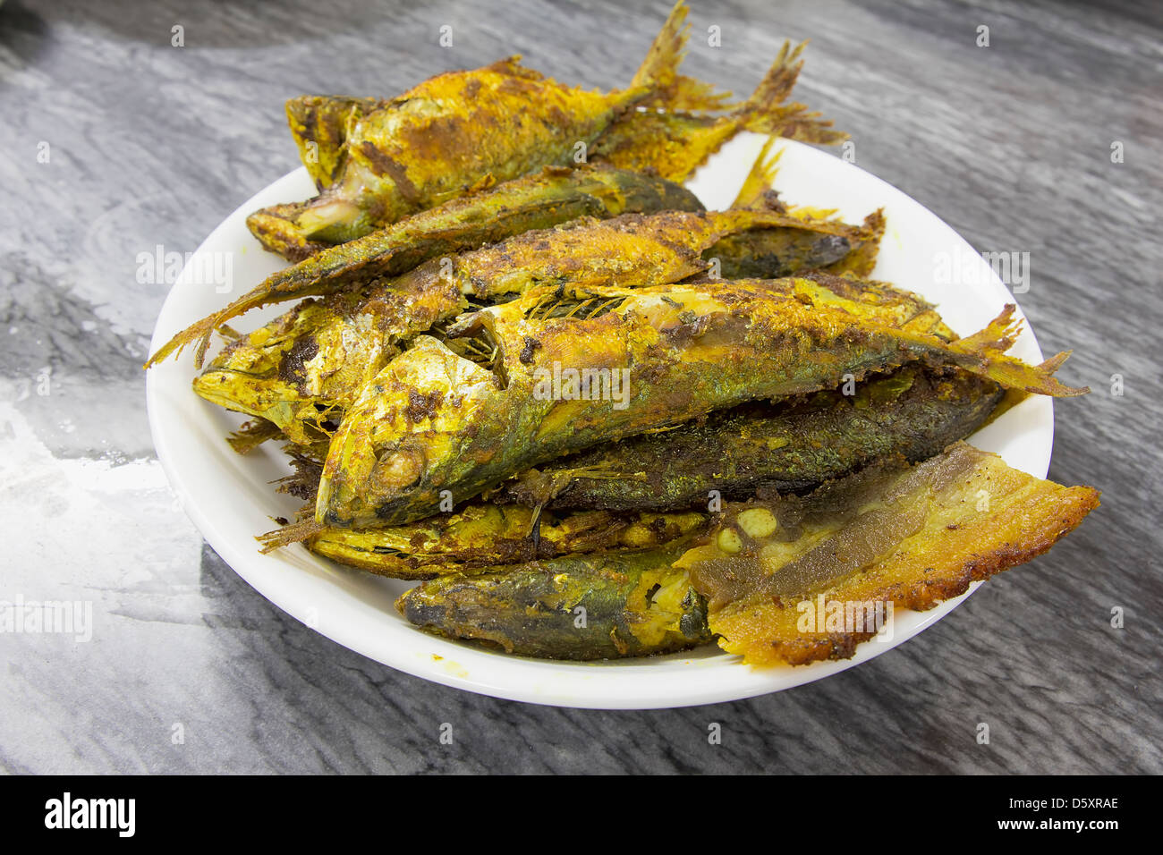 Fritte Selar Kuning pesce conditi con spezie Curry Foto Stock