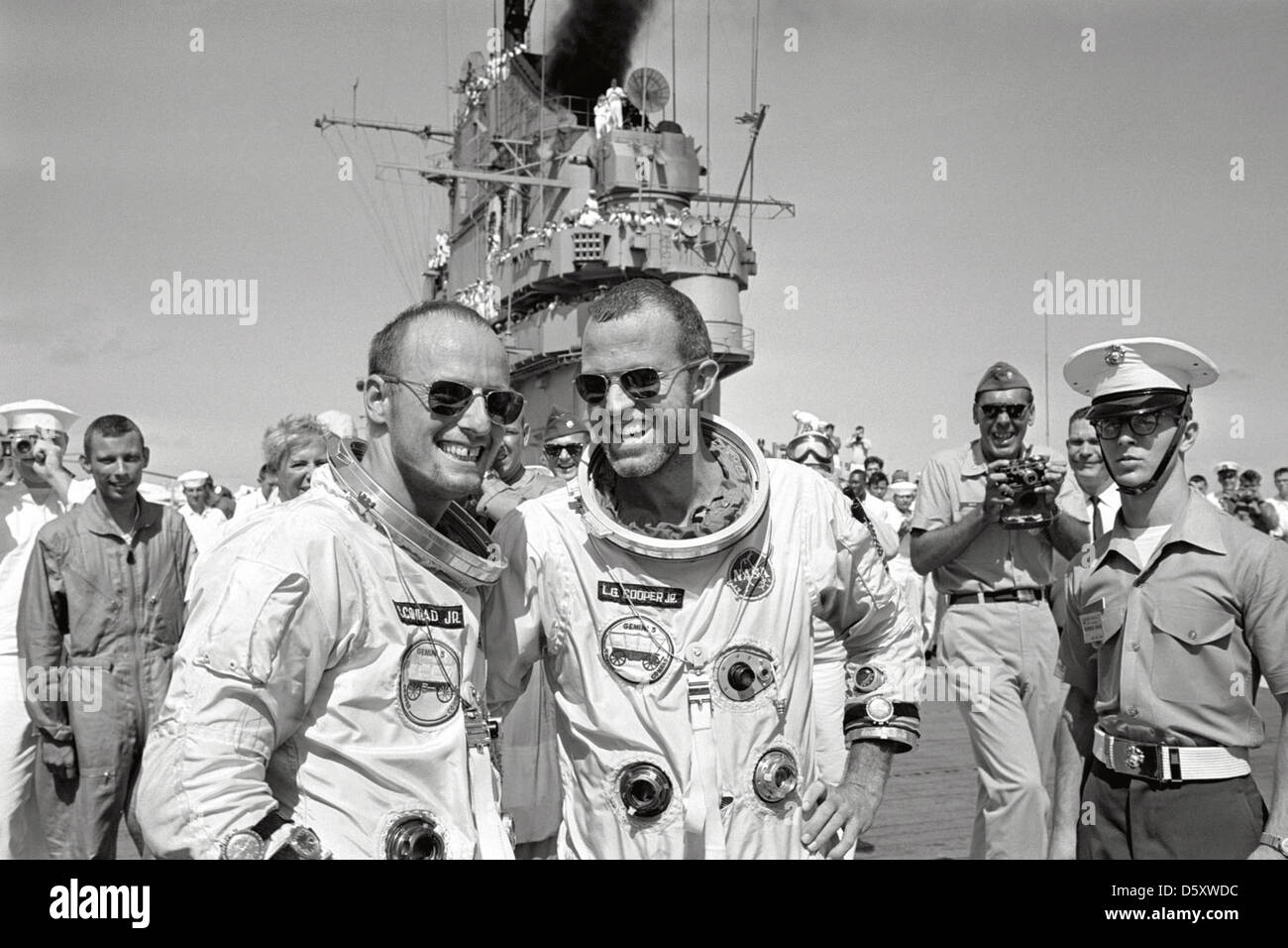 Stati Uniti gli astronauti l. Gordon Cooper jr. (A DESTRA) e Charles Conrad jr. a piedi attraverso il piano di recupero della portaerei USS Lake Champlain (CV-39) a seguito di splashdown e recupero dall'oceano, aug. 29, 1965. Foto Stock