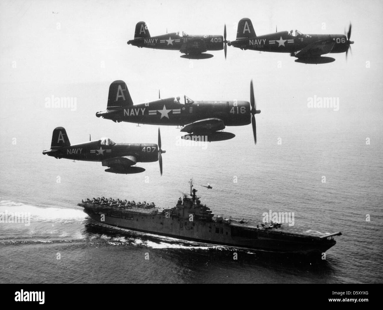 Quattro corsari Chance-Vought F4U-4 della US Navy del Fighter Squadron VF-884, noti come gli "uccelli amari", tornano da una missione di combattimento sulla Corea del Nord e volano oltre la USS Boxer (CV-21) il 4 settembre 1951 durante la guerra di Corea. Foto Stock