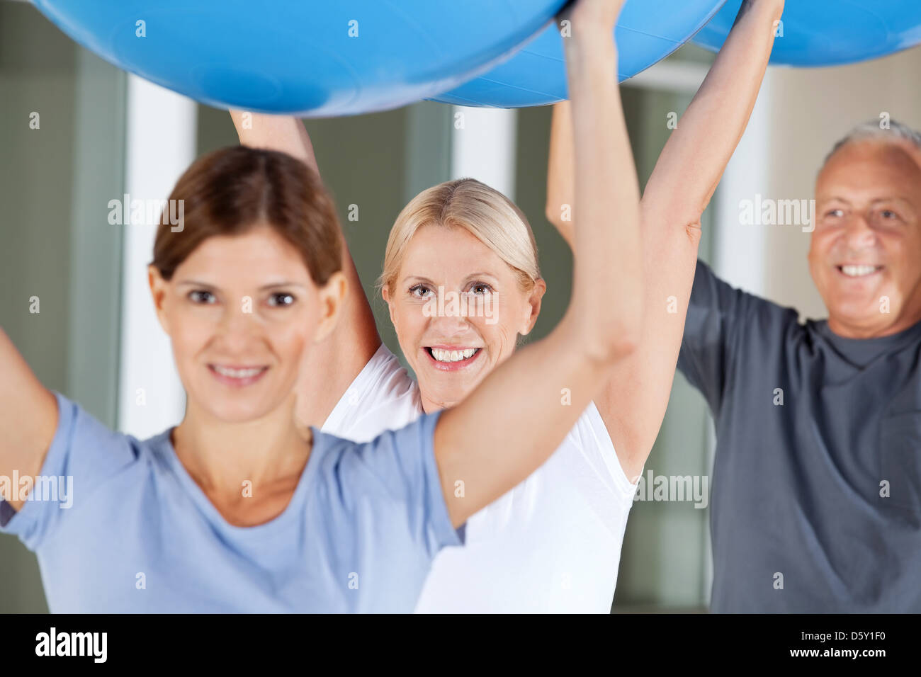 Felice di anziani facendo esercizi di riabilitazione con palestra palle nel centro fitness Foto Stock