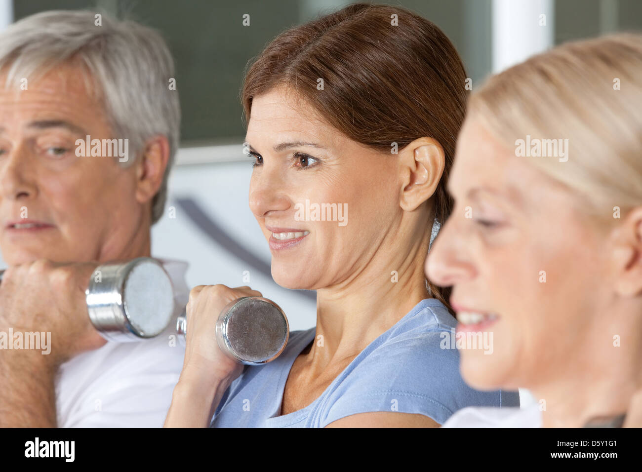 I cittadini anziani facendo dumbbell formazione nel centro fitness Foto Stock