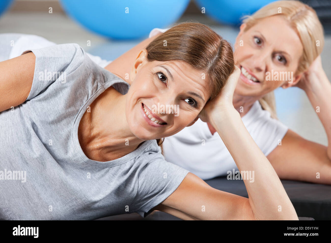 Felici donne relax su palestra stuoie nel centro fitness Foto Stock