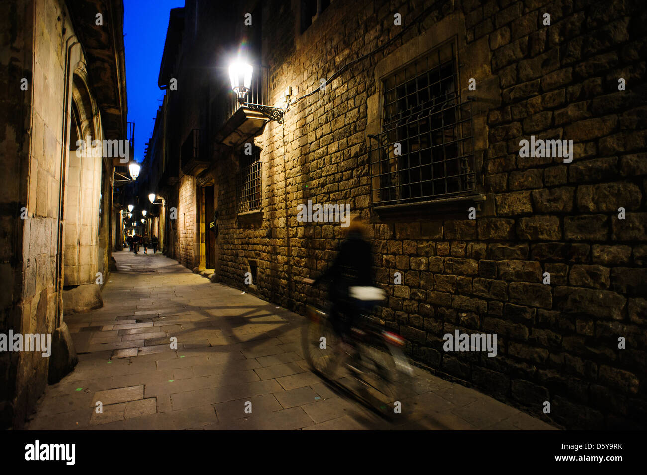 Una persona in sella ad una bici nel quartiere gotico di Barcellona durante la notte. Spagna Foto Stock