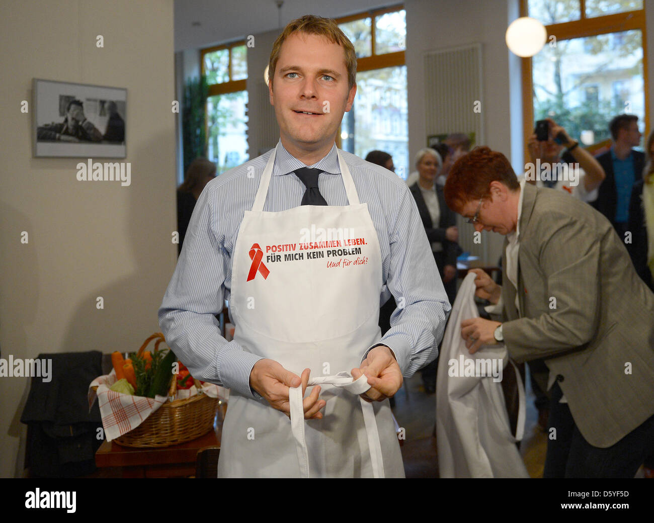 Ministro tedesco della Sanità Daniel Bahr mette un grembiule in cucina di ZIK ("Home nel cofano") di Berlino, Germania, 23 ottobre 2012. Quattro uomini e donne stand alla loro infezione da HIV in occasione dell'azione "L'HIV positivi e nel mezzo della vita". L'azione chiede più tolleranza, rispetto e sostegno dei soggetti HIV positivi prima della Giornata Mondiale contro l Aids del 01 dicembre. Foto: Britta Foto Stock