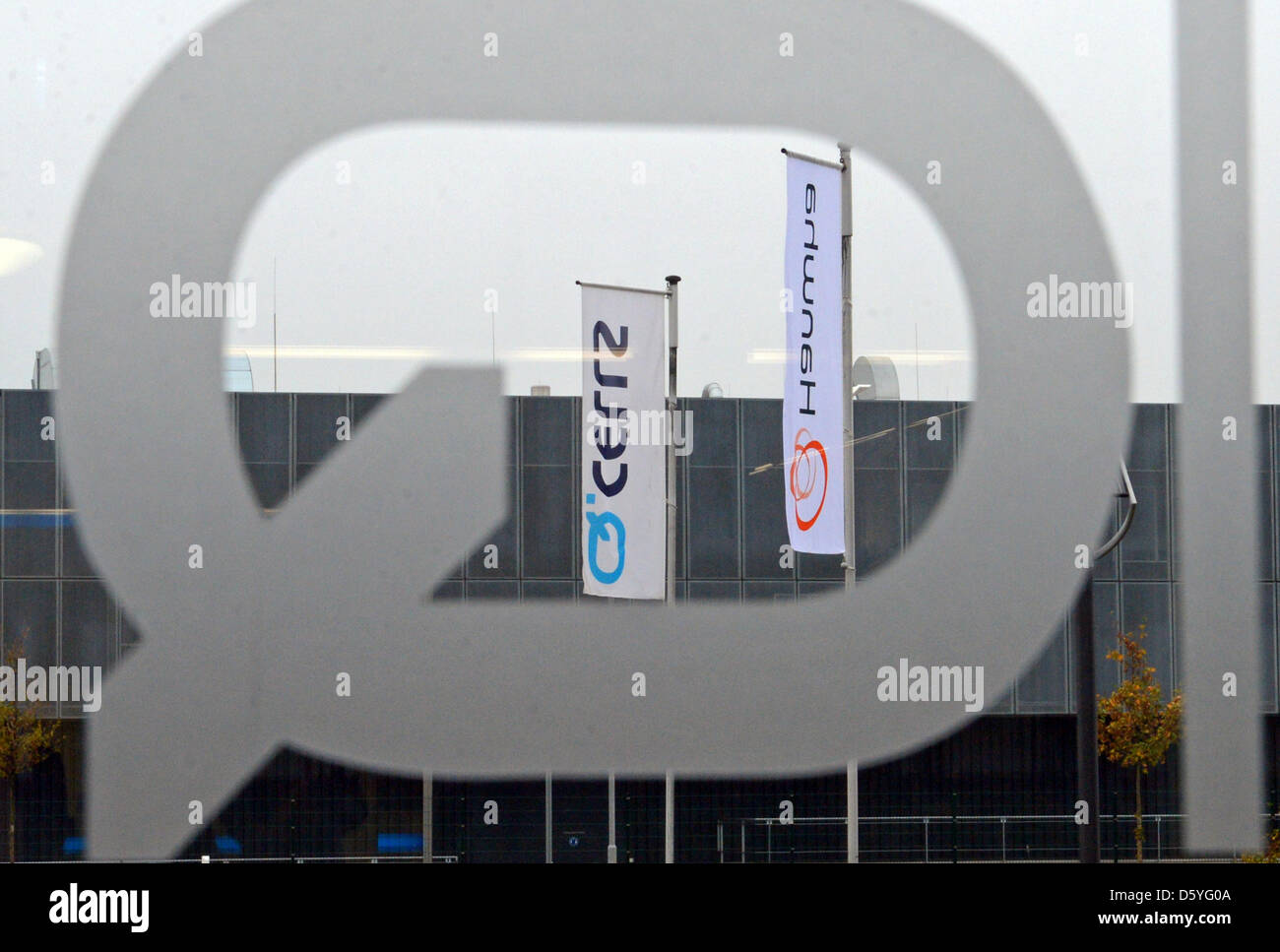 Il logo di società di Q.cellule e di Hanwha sono visibili attraverso una porta di vetro presso il sito aziendale di Q.cellule in Thalheim, Germania, 24 ottobre, 2012. Q.cellule e sud coreani sono Hanwha sperando per nuove sinergie dopo la recente fusione di società. In tutto il mondo il terzo più grande produttore di celle solari 'Hanwha Q.cellule" mira a consolidare la sua posizione sul mercato. Foto: Hendrik Schmidt Foto Stock