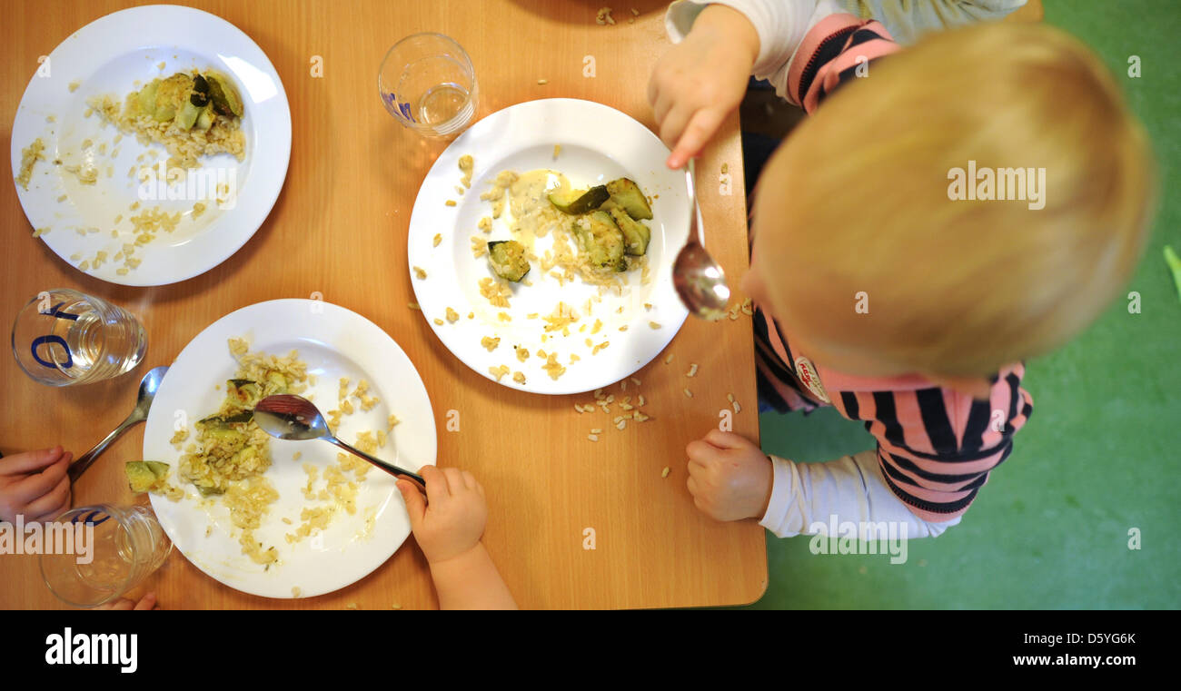 I bambini mangiano il loro organico, pranzo vegetariano da piastre in una scuola materna a Hannover, Germania, 23 ottobre 2012. Pasti organici nella scuola e le scuole materne sono diventati un problema di dibattito pubblico in Germania. Foto: Julian Stratenschulte Foto Stock