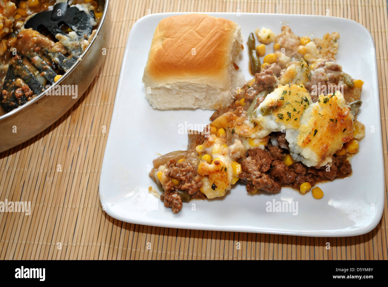 Appetitoso che serve di Shepards Pie con un rotolo di cena Foto Stock