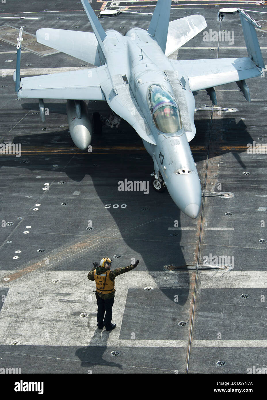 US Navy marinai segnali ad un Marine Corps F/A-18C Hornet aerei sul ponte di volo della portaerei USS Nimitz Aprile 4, 2013 nell'Oceano Pacifico. Foto Stock