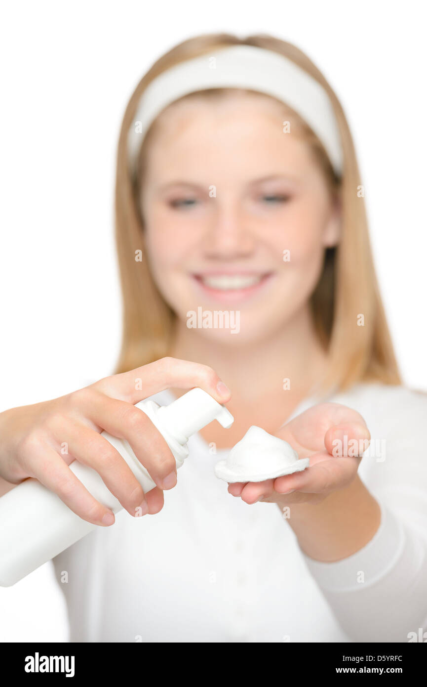 Allegro adolescente ragazza utilizzando schiuma detergente crema idratante Foto Stock
