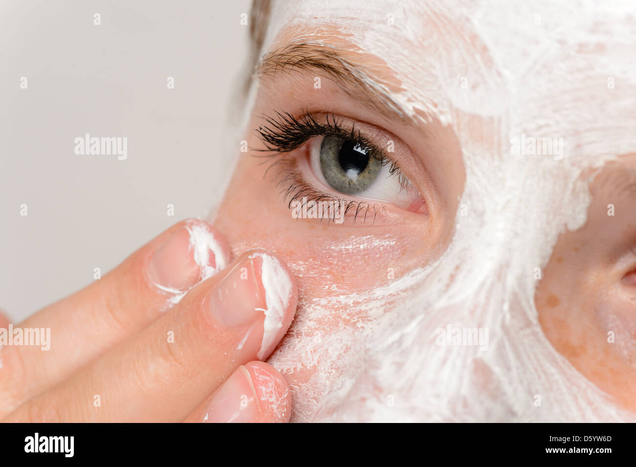 Ragazza giovane dita di applicare la maschera per il viso idratante della pelle di pulizia Foto Stock