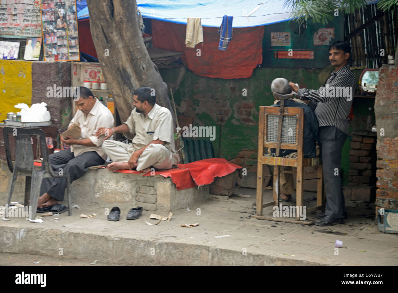 Realizzare localmente un negozio da barbiere in una strada laterale di Nuova Delhi in India Foto Stock
