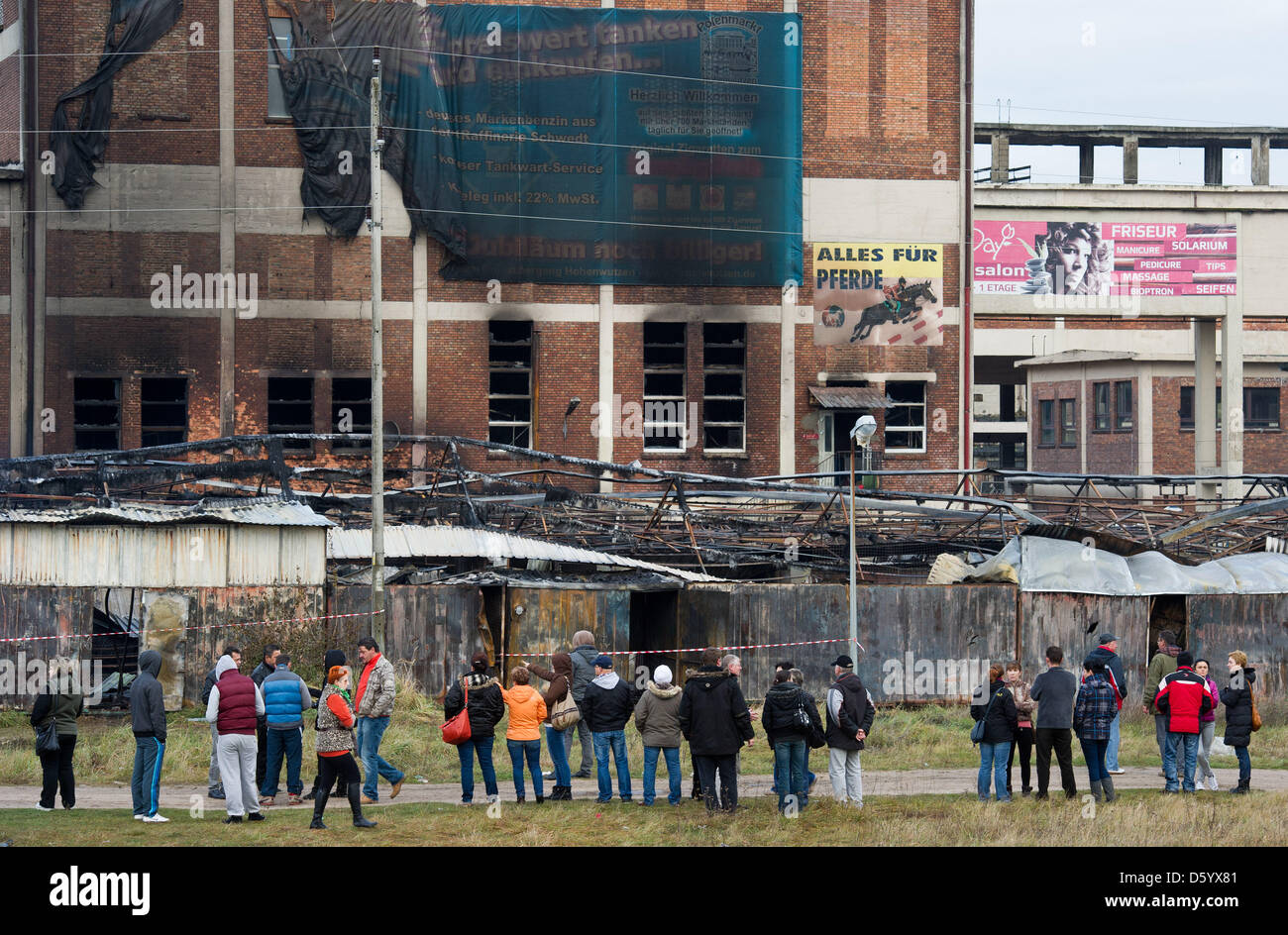 Le persone si mettono di fronte completamente bruciato giù le cabine in un mercato vicino alla città polacca Osinow Dolny vicino al confine con la Hohenwutzen, Germania, 05 novembre 2012. Un grande incendio ha distrutto vaste parti del mercato e più di 100 le forze dei vigili del fuoco nel Land di Brandeburgo hanno aiutato i loro colleghi polacchi per mettere fuori fuoco. Foto: Patrick Pleul Foto Stock