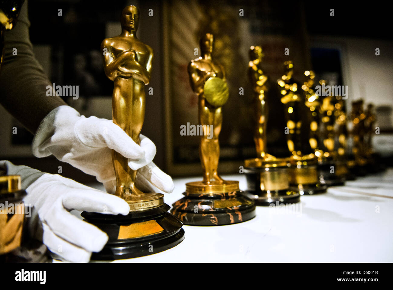 Un dipendente della "Accademia delle Arti e delle scienze cinematografiche' indossa guanti bianchi come posizioni di lei un Oscar statua al film tedesco Museum di Francoforte sul Meno, Germania, 07 novembre 2012. La mostra 'e l'Oscar vai a ... 85 anni di migliore immagine' avviene tra 14 novembre 2012 e 28 aprile 2013. Foto: NICOLAS ARMER Foto Stock