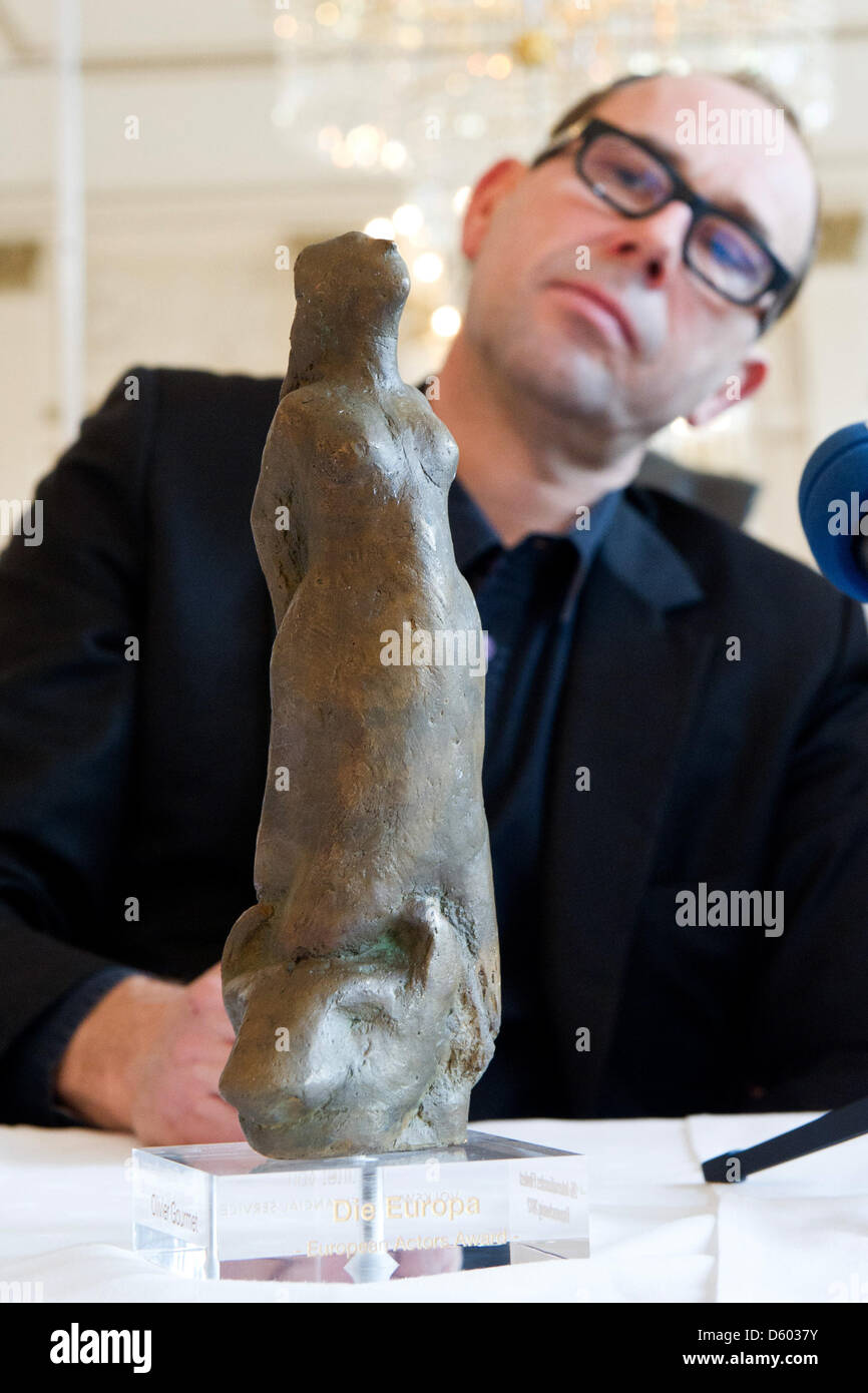 Attore belga Olivier Gourmet guarda al suo premio 'Die Europa" presso il Teatro di Stato di Braunschweig, Germania, 11 novembre 2012. Egli ha ricevuto gli attori award' 'Die Europa' durante la XXVI Festival Internazionale del Film di Braunschweig. Il premio principale è dotato di 10.000 euro. Foto: TOBIAS KLEINSCHMIDT Foto Stock