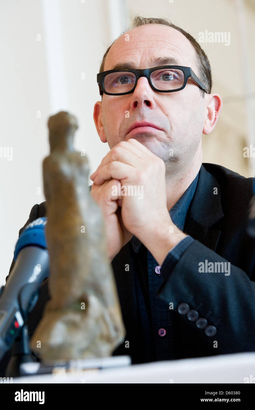 Attore belga Olivier Gourmet guarda al suo premio 'Die Europa" presso il Teatro di Stato di Braunschweig, Germania, 11 novembre 2012. Egli ha ricevuto gli attori award' 'Die Europa' durante la XXVI Festival Internazionale del Film di Braunschweig. Il premio principale è dotato di 10.000 euro. Foto: TOBIAS KLEINSCHMIDT Foto Stock