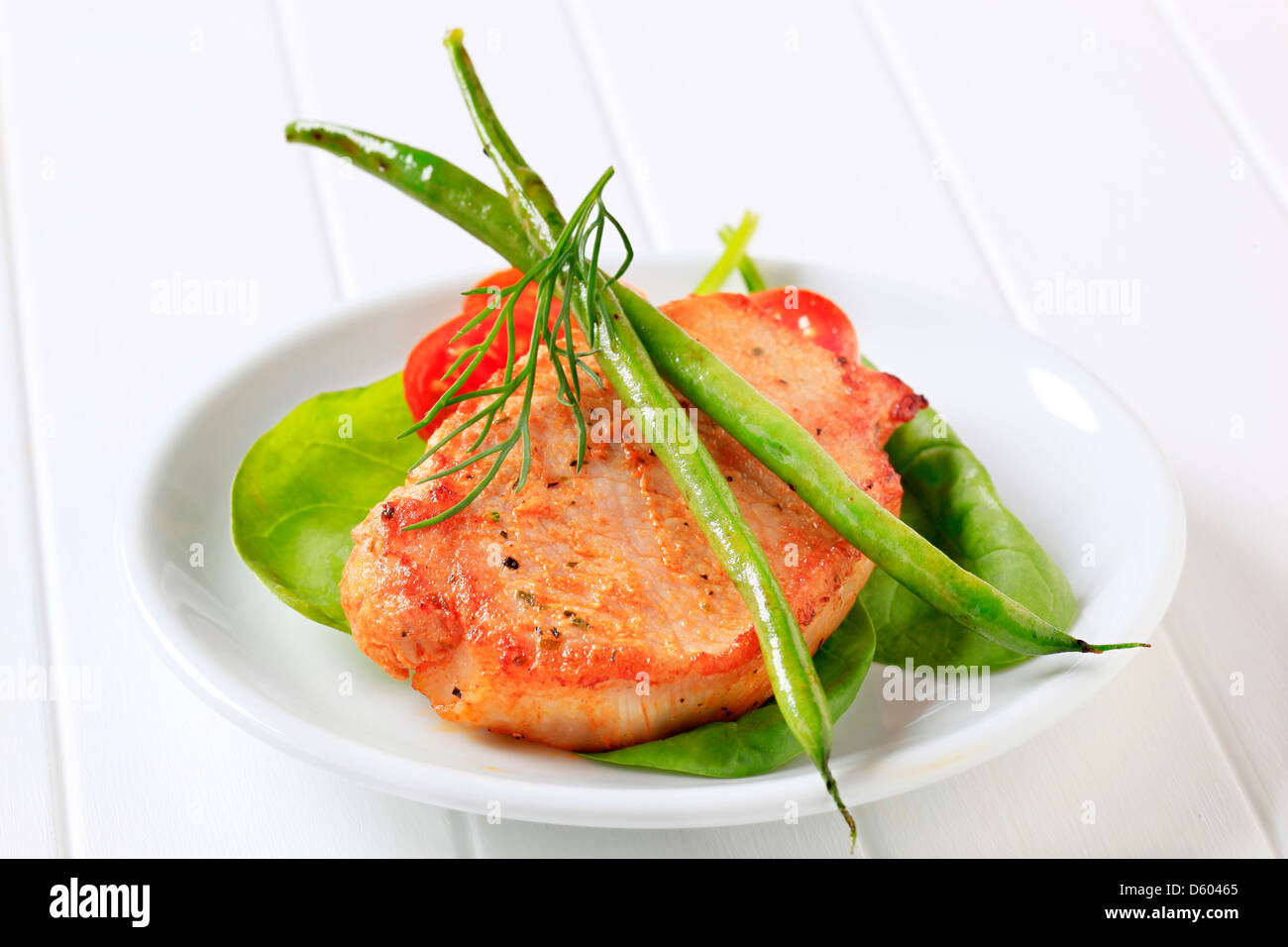 Carne di maiale marinato chop accompagnata da verdure Foto Stock