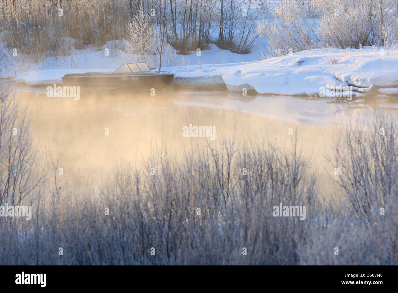 Piccola barca sul fiume in molto fredda mattina, con aria per la cottura a vapore. Europa Foto Stock