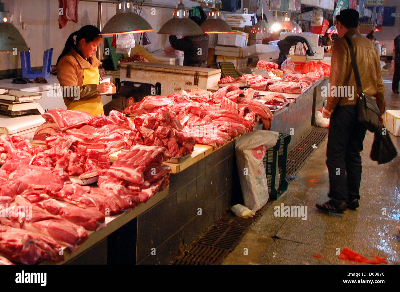 Pechino, 09 aprile 2013. Una donna vende carne in un mercato hall di Pechino. La nuova influenza aviaria H7N9 mantiene la Cina in suspense: nessuno sa quanto l'influenza si è diffusa e la gente mangia meno volatili. Foto: Stephan Scheuer/DPA/Alamy Live News Foto Stock