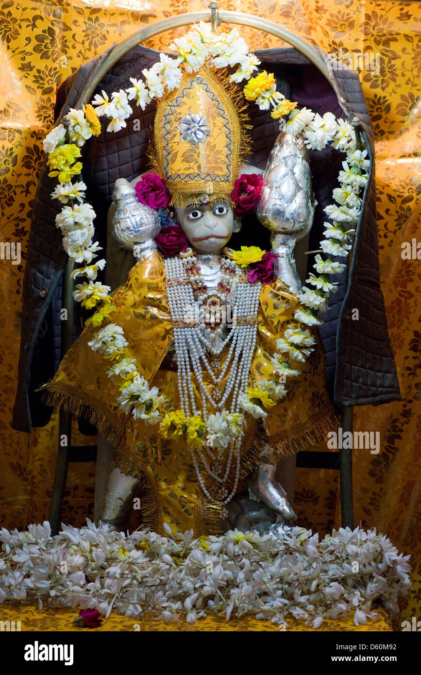 Offerte di fiori adornano una statuetta della divinità Indù Hanuman presso un santuario in Udaipur, Rajasthan, India Foto Stock