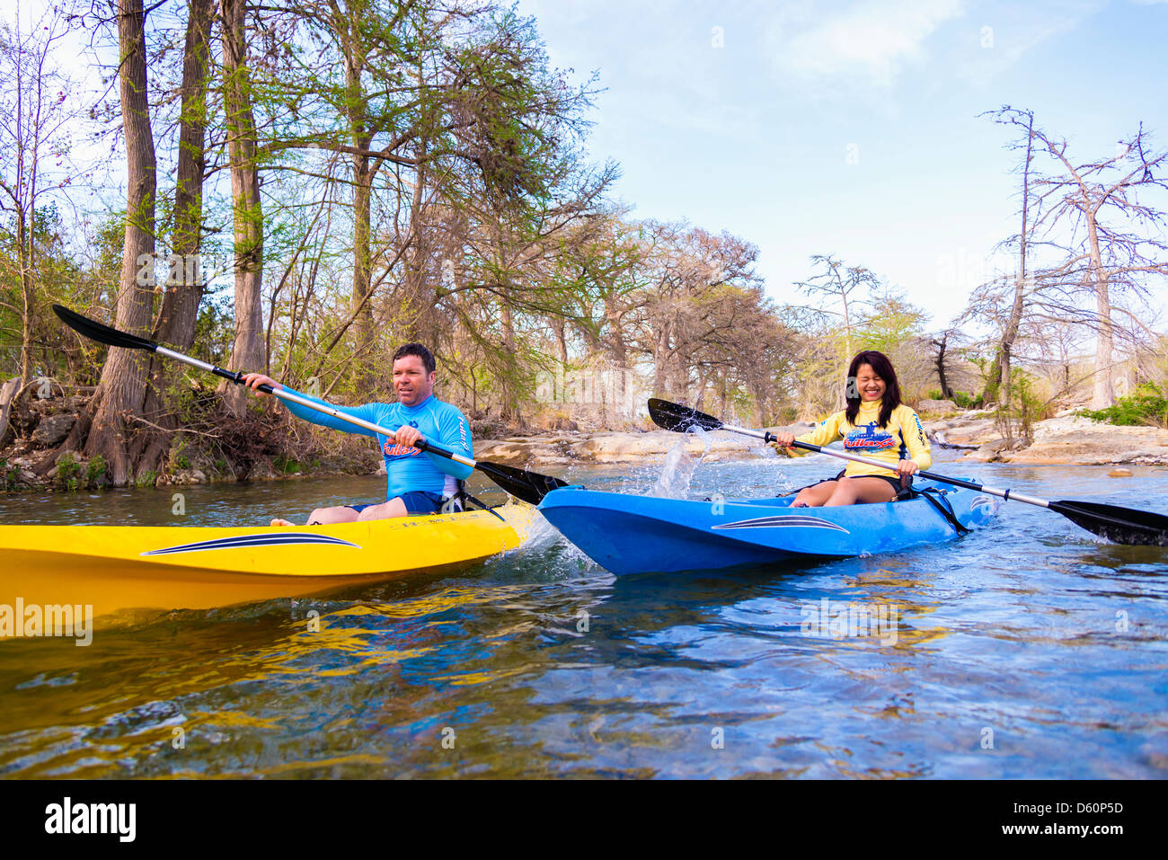 Uomo di mezza età e la giovane donna in kayak sul fiume Frio, Texas, Stati Uniti d'America Foto Stock
