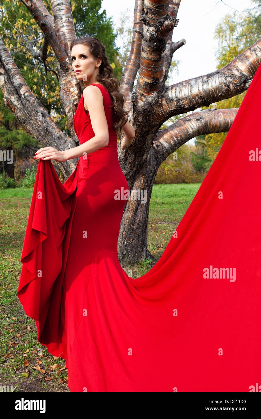 Una bella bruna in abito rosso Foto Stock