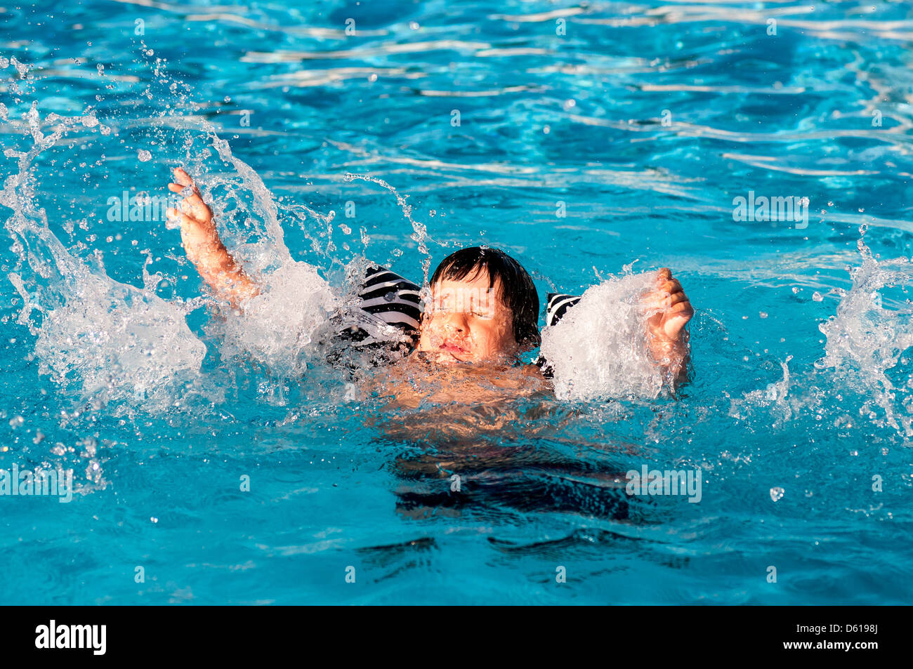 Ragazzo giovane annegamento in piscina Foto Stock