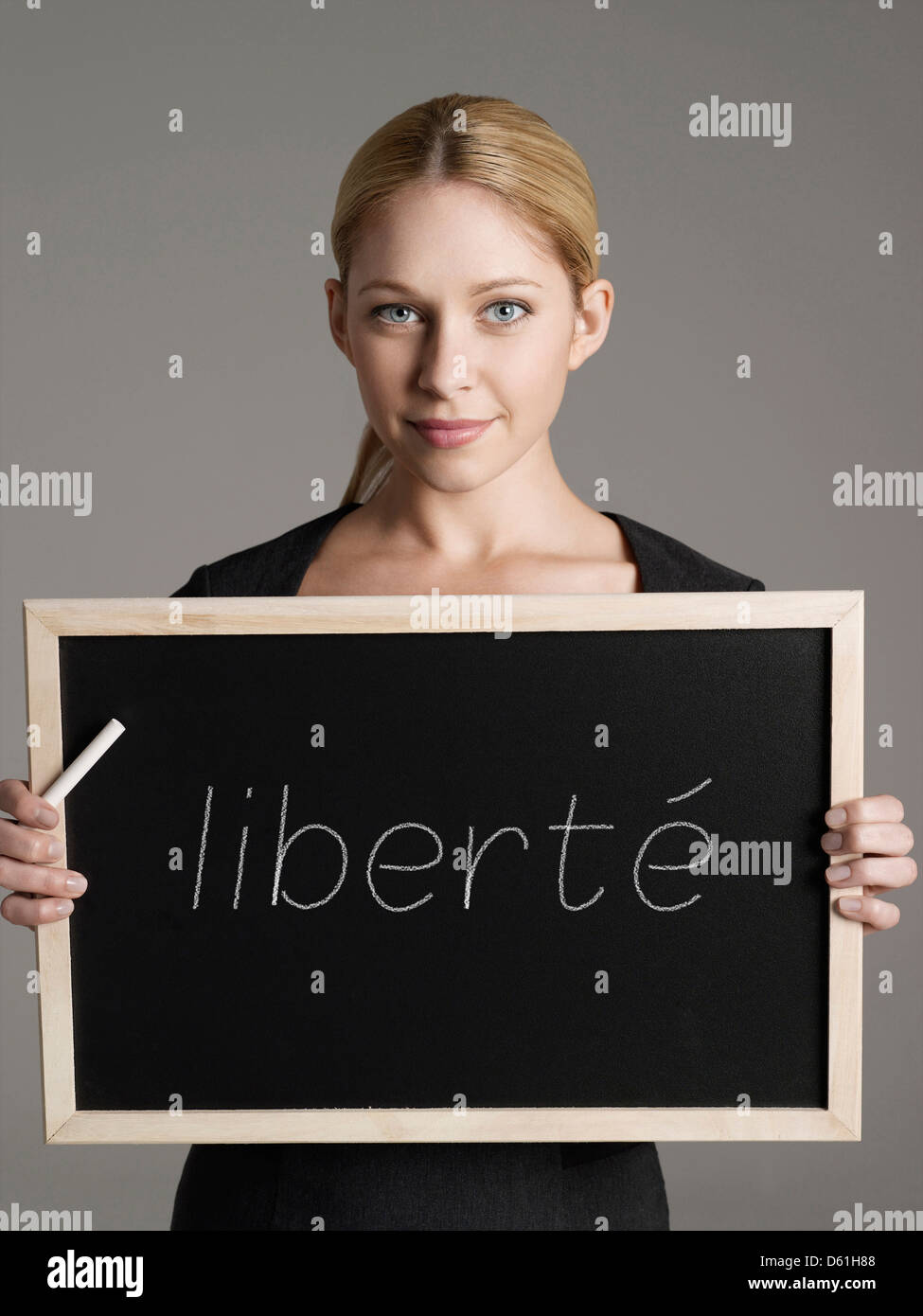 Ritratto di giovane imprenditrice azienda lavagna con testo francese 'liberté' (libertà) Foto Stock