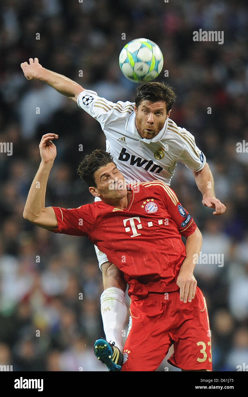 Monaco di Baviera è Mario Gomez e di Madrid Xabi Alonso (top) vie per la palla durante la Champions League semi finale seconda gamba partita di calcio tra il Real Madrid e FC Bayern Monaco di Baviera al Santiago Bernabeu a Madrid, Spagna, 25 aprile 2012. Foto: Marc Mueller dpa +++(c) dpa - Bildfunk+++ Foto Stock