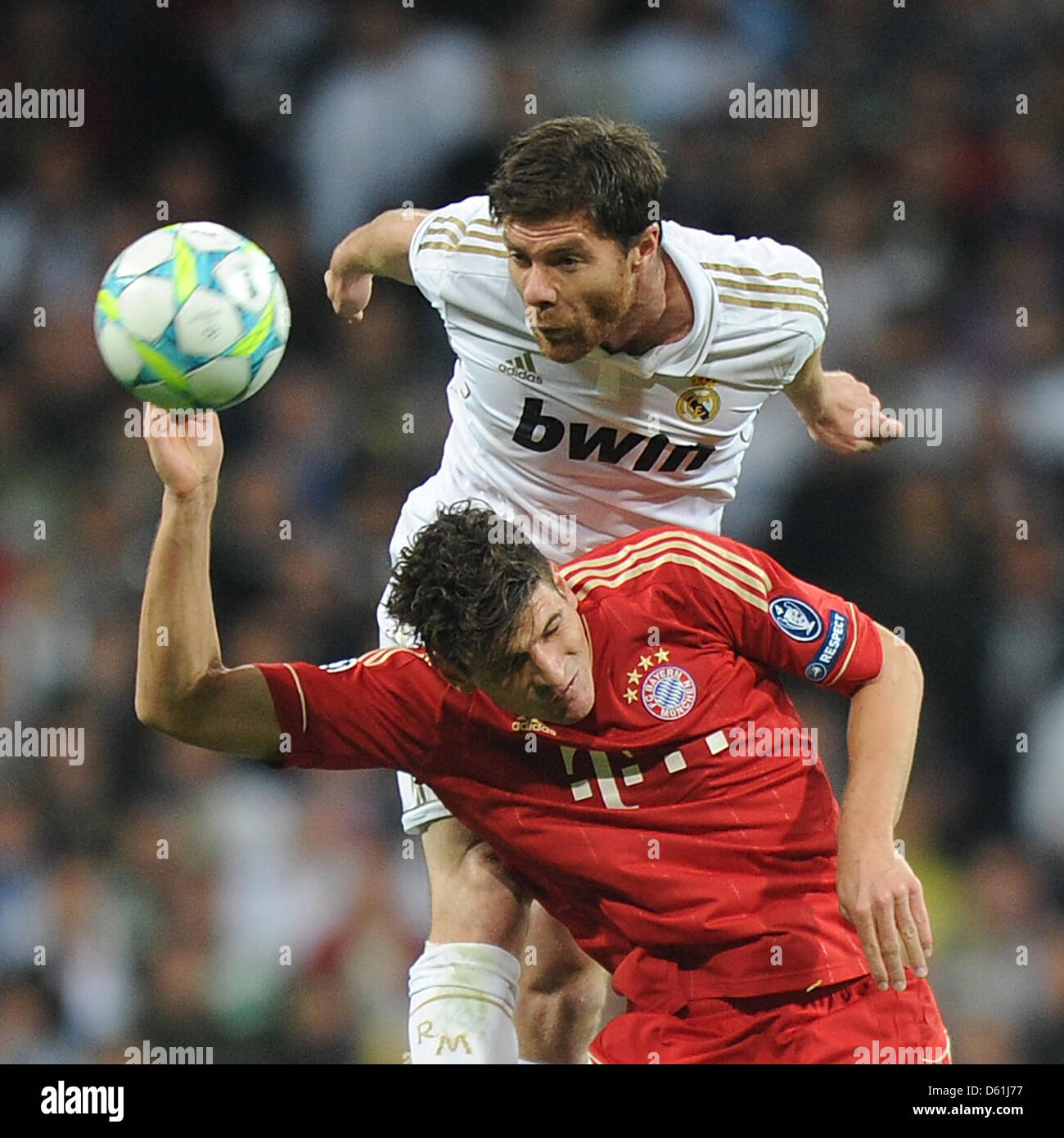 Monaco di Baviera è Mario Gomez e di Madrid Xabi Alonso (top) vie per la palla durante la Champions League semi finale seconda gamba partita di calcio tra il Real Madrid e FC Bayern Monaco di Baviera al Santiago Bernabeu a Madrid, Spagna, 25 aprile 2012. Foto: Marc Mueller dpa +++(c) dpa - Bildfunk+++ Foto Stock