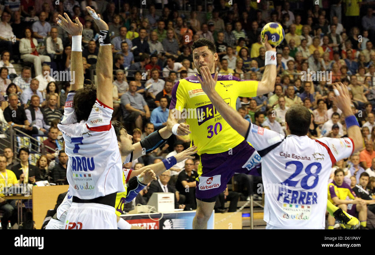 Berlin Alexander Petersson (M) salta a sparare al netto di Leon's Alvaro Ferrer Vecilla (R) e Carou Marcel Gonzalo (L) durante gli uomini in Champions League quarti di finale della seconda gamba match tra Berlino volpi e Ademar Leon a Max-Schmelinghalle a Berlino, Germania, 29 aprile 2012. Foto: WOLFGANG KUMM Foto Stock