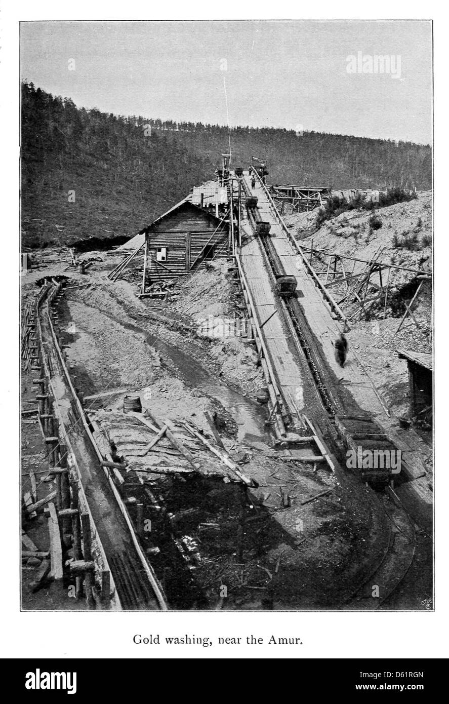 Questa immagine tratta dalla pubblicazione del 1901 "Un nastro di ferro" si concentra sulla regione del fiume Amur, raffigurante il processo di lavaggio dell'oro nella zona. Il fiume Amur, che forma parte del confine tra Russia e Cina, fu un sito importante per l'estrazione mineraria all'inizio del XX secolo. Foto Stock