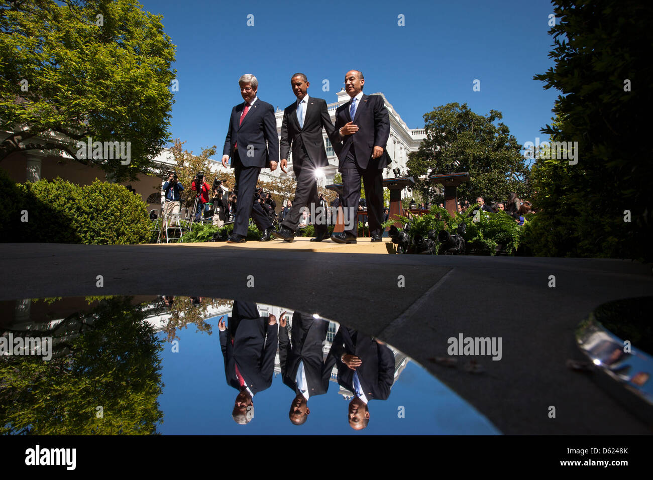 Il Presidente degli Stati Uniti Barack Obama passeggiate con il Primo Ministro Stephen Harper del Canada, sinistra e Presidente Felipe Calderón del Messico a seguito della loro conferenza stampa congiunta nel Giardino delle Rose della Casa Bianca, 2 aprile 2012. I tre leader sono riflesse nella base di bandiera poli situato sul colonnato. .Credito: Chuck Kennedy - White House via CNP Foto Stock