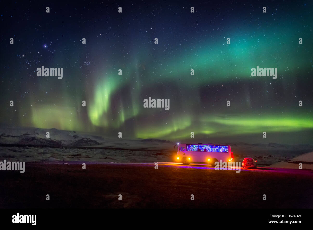 Aurora Boreale o luci del nord. Bus e auto dal Jokulsarlon, Breidarmerkurjokull, Vatnajokull calotta di ghiaccio, Islanda Foto Stock