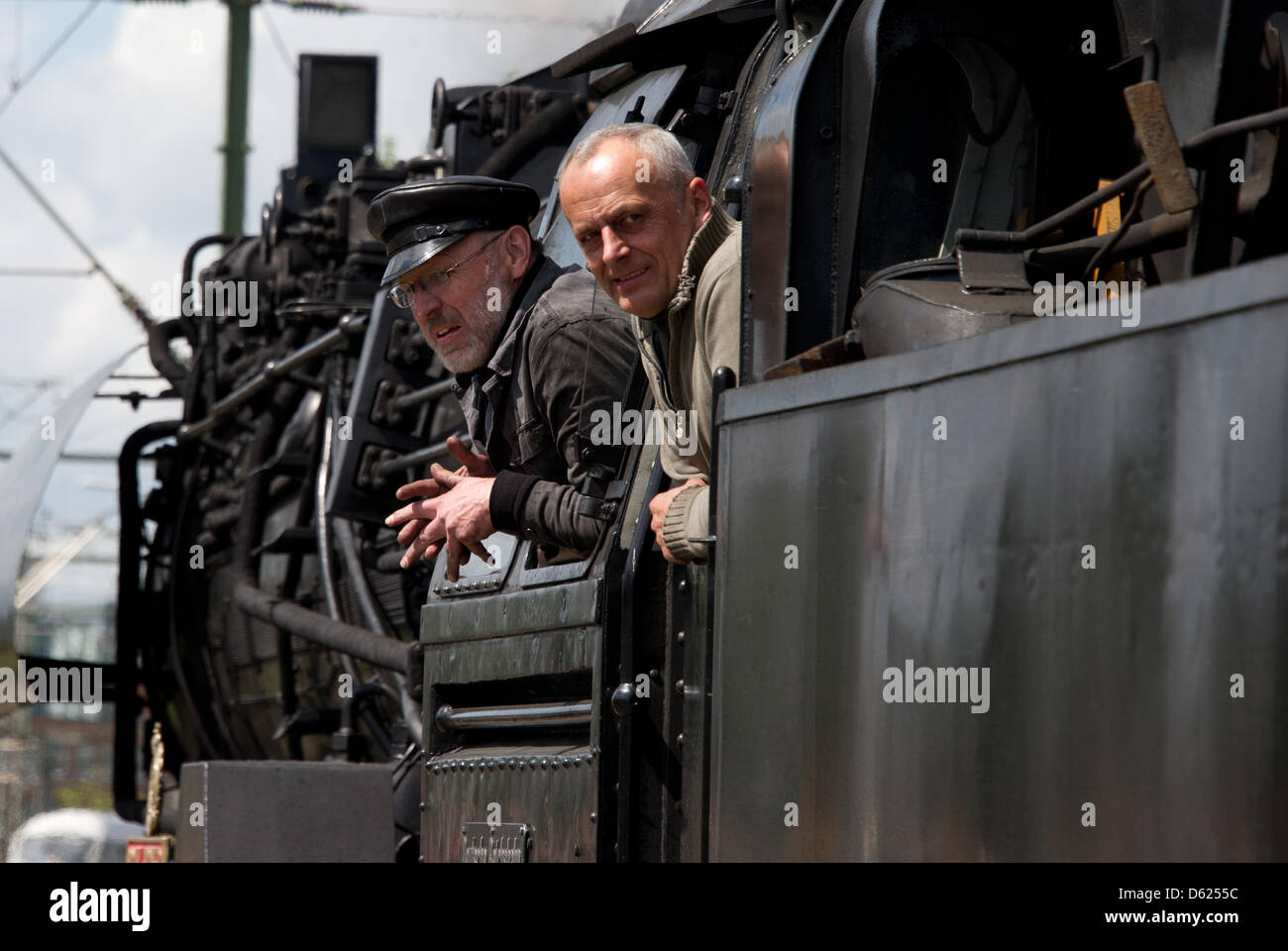 Ingegnere Tommaso Lautenschlaeger (R) e vigile del fuoco Harald Gebser (L) salutare il pubblico dall'interno di uno storico treno a vapore nella stazione centrale di Hannover, Germania, 12 maggio 2012. In ricordo della divisione tedesca, i politici e gli ex militari generali percorsa da Hannover a Berlino con il treno a vapore. Foto: JOCHEN LUEBKE Foto Stock